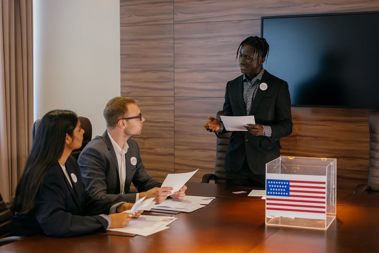 our-story Multiracial group of professionals engaged in a political meeting with a ballot box.